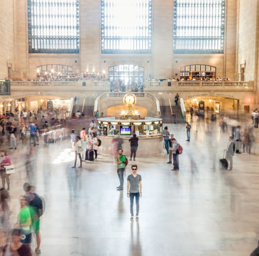 Person standing in crowded train station. Photo by Thomas Lefebvre on Unsplash